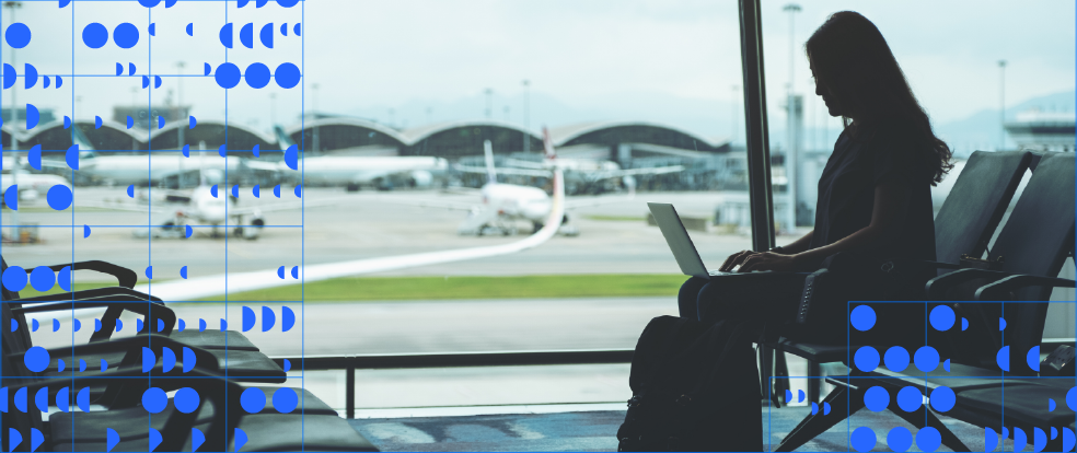 Traveler on laptop at airport, decorative data moons and grid