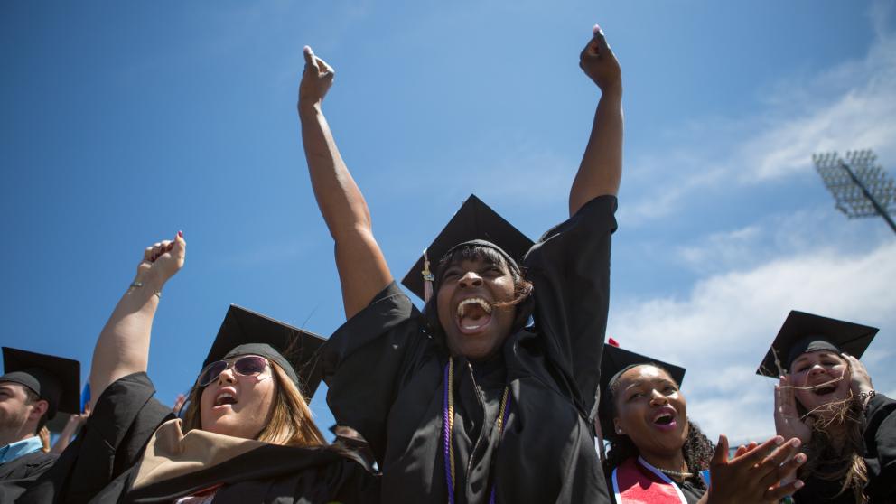 Students in caps and gown celebrating graduation.